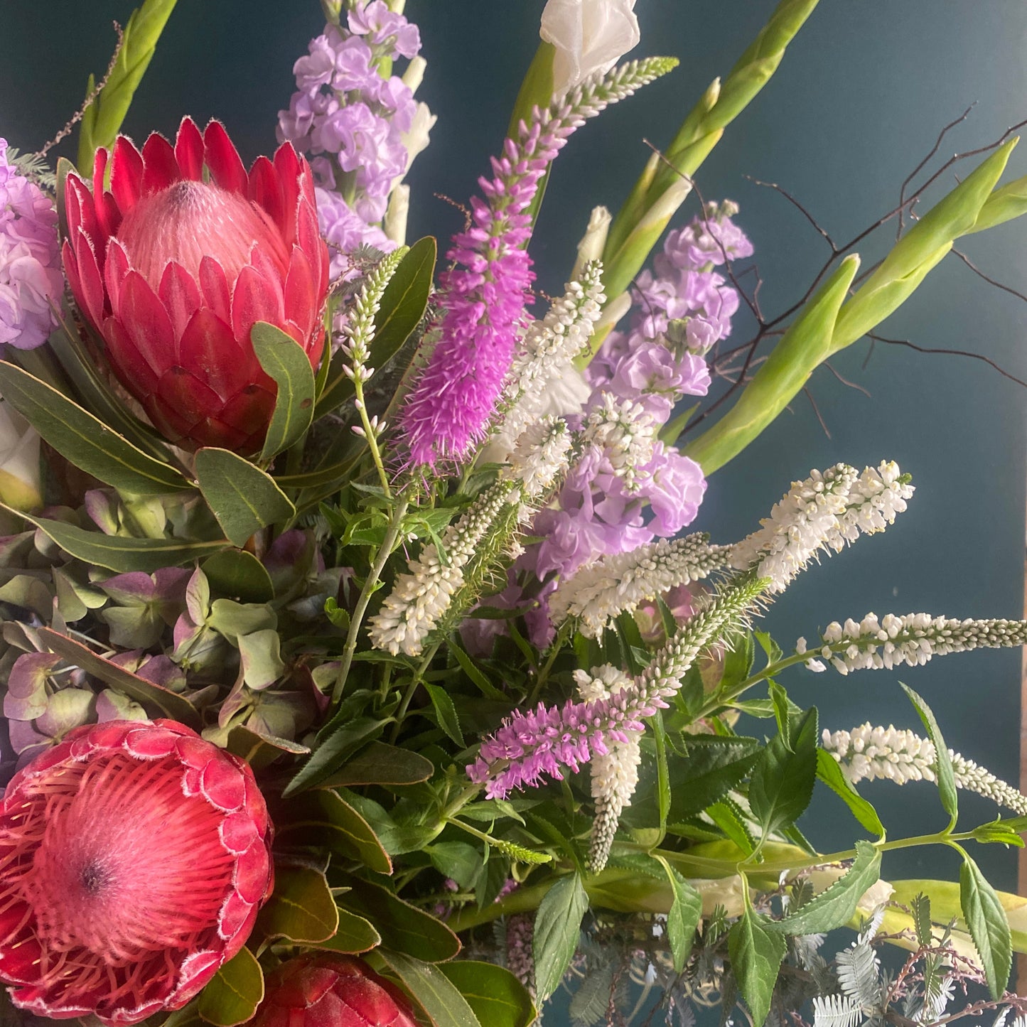 Native pink proteas and delicate seasonal flowers in a pink and lilac colour palette