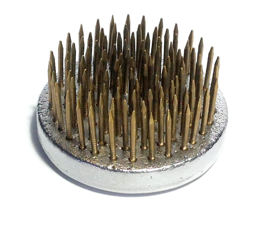 A small, circle shaped Kenzan flower pin, used for foam free flower arranging in a vase