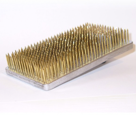 A large, rectangle shaped Kenzan flower pin, used for foam free flower arranging in a vase