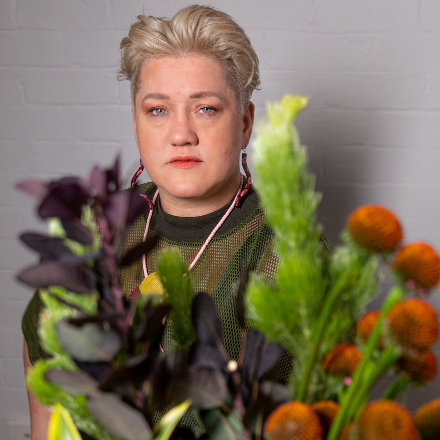 Your florist Suzanne standing and showing some textural greenery and echinacea stems.