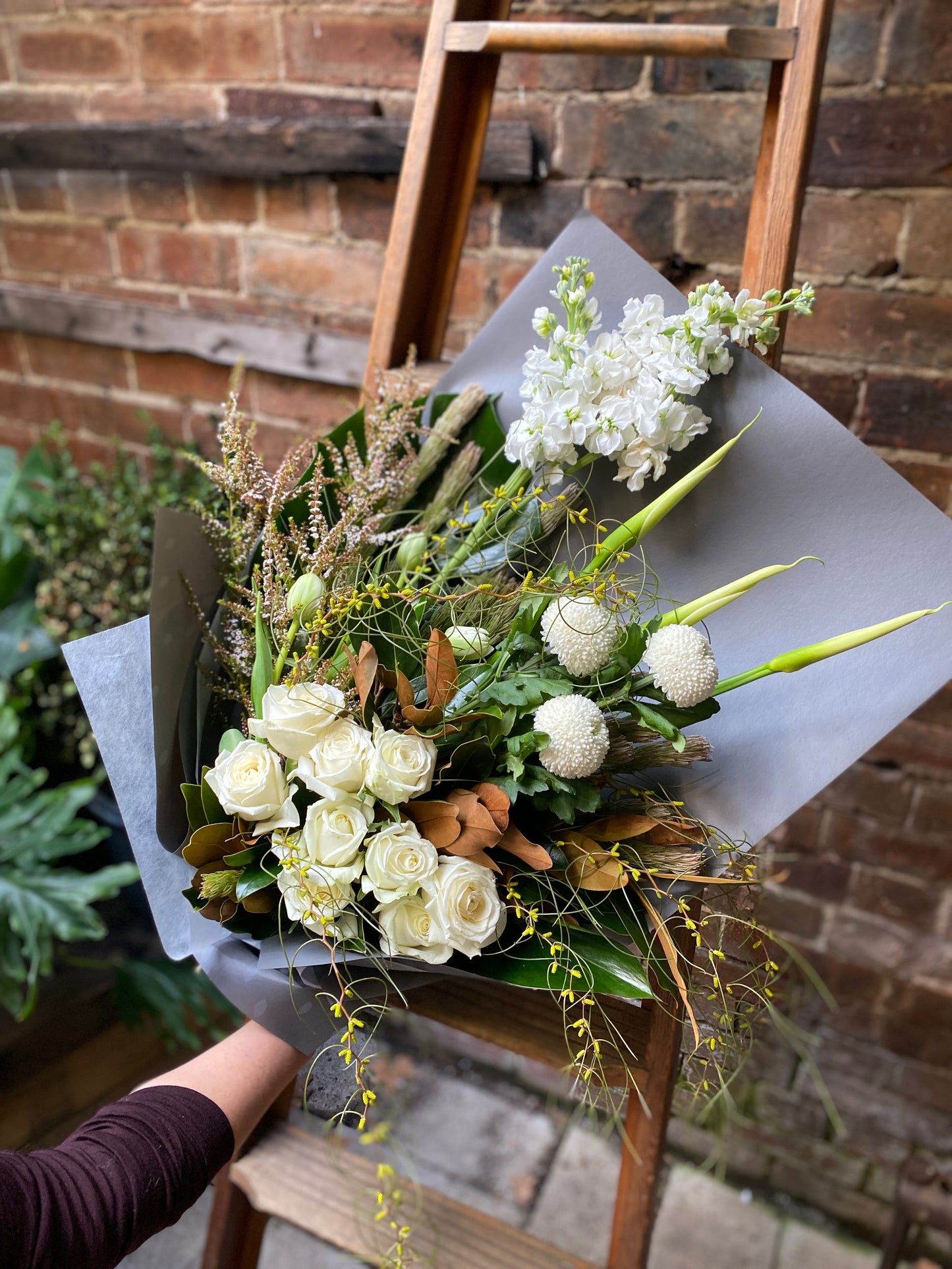 A medium sized floral arrangement of white and native flowers