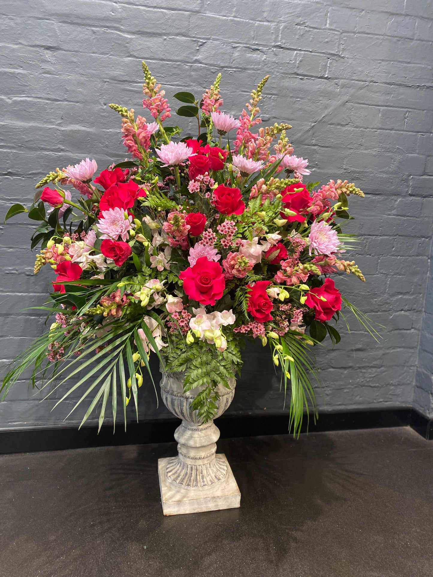 Extra large funeral floral arrangement of red, pink and white flowers by Bold Botanicals
