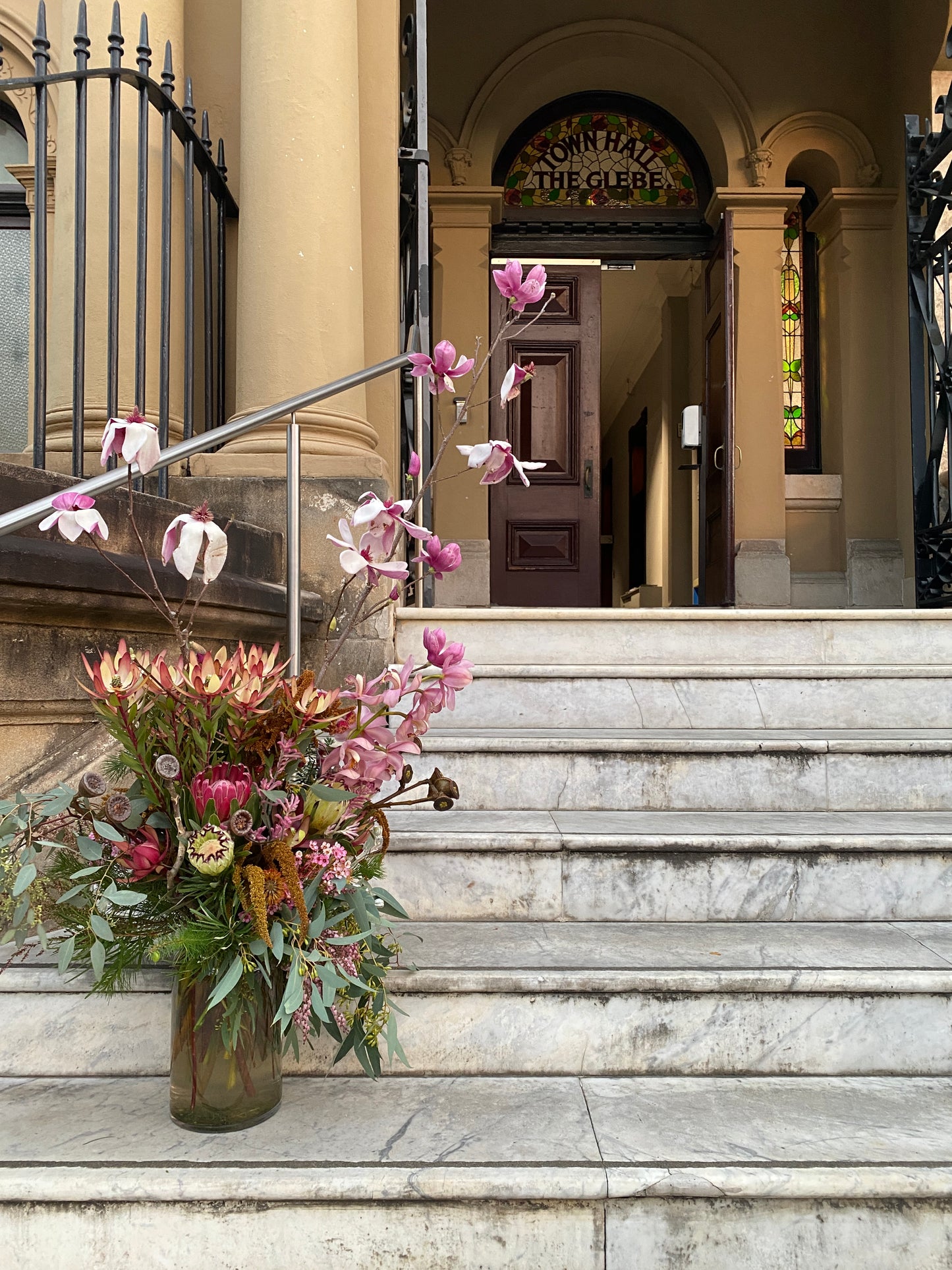 A grand arrangement of australian native flowers and seasonal Magnolia, being delivered to a Town Hall Funeral.