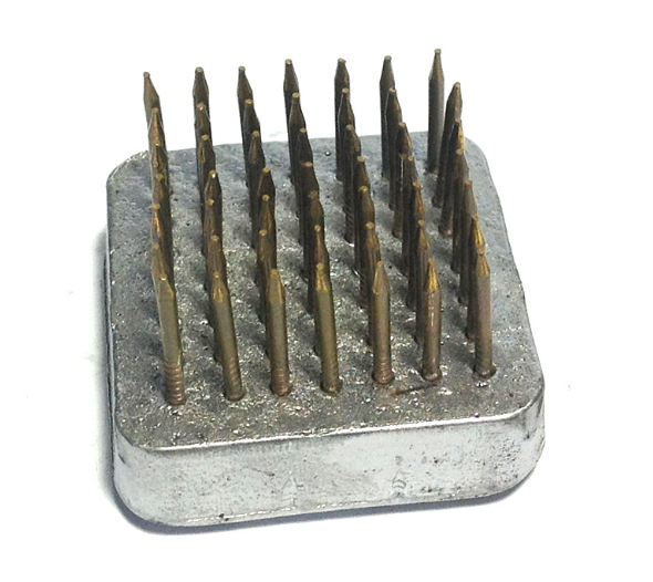 A large, square shaped Kenzan flower pin, used for foam free flower arranging in a vase