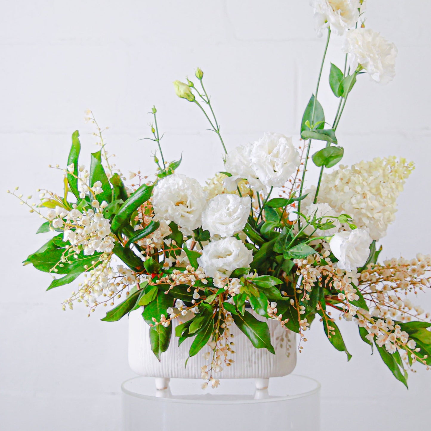 Low white ceramic trough with a white flower display