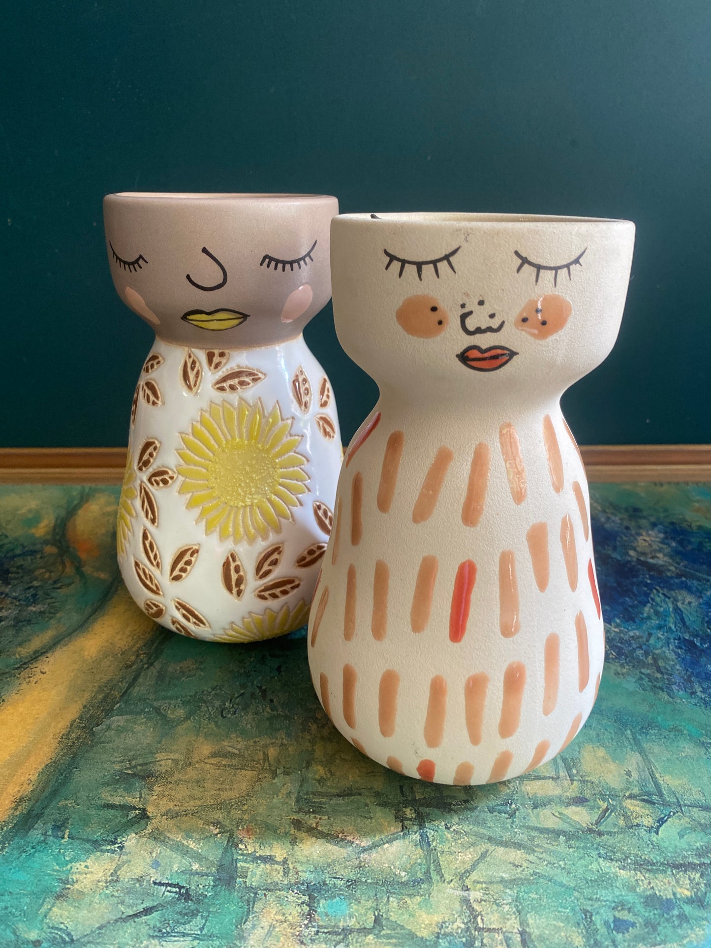 Two Jones and co ceramic vase with painted faces in bright colours