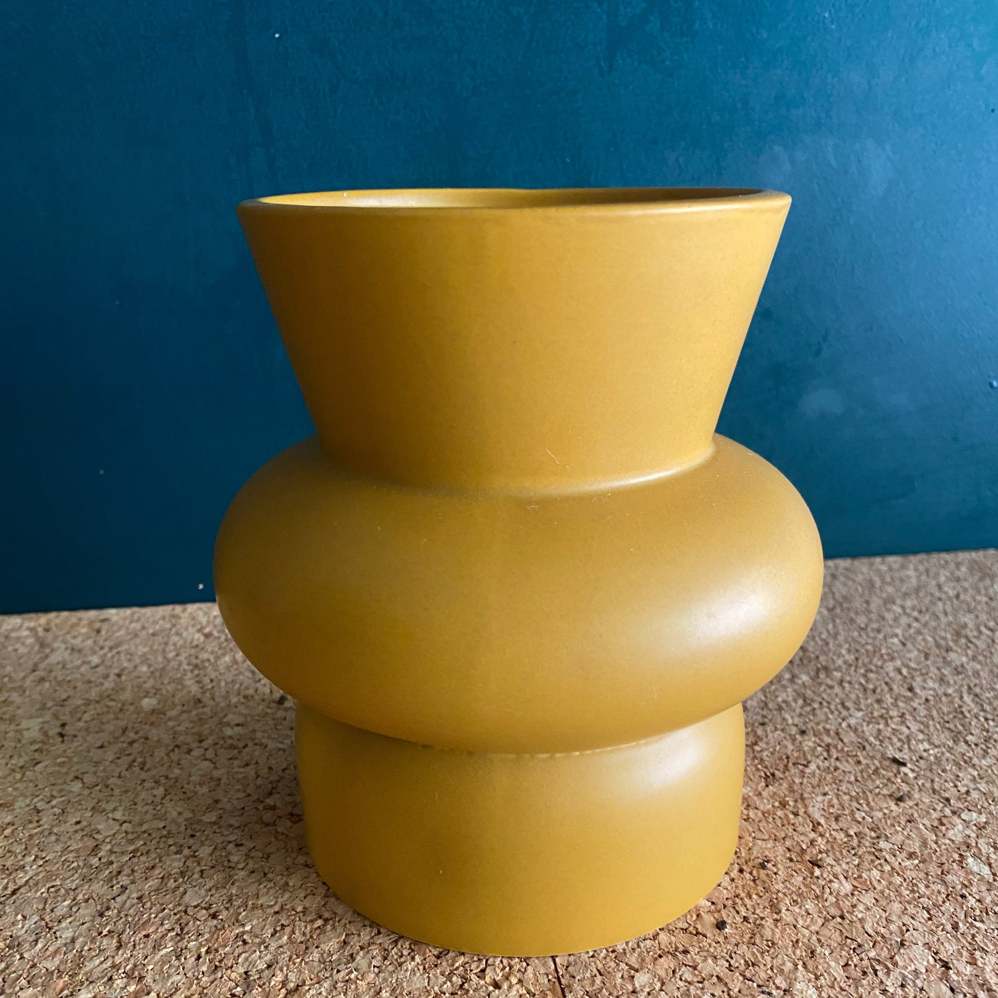 Mustard yellow ceramic vase in curvy geometric shape