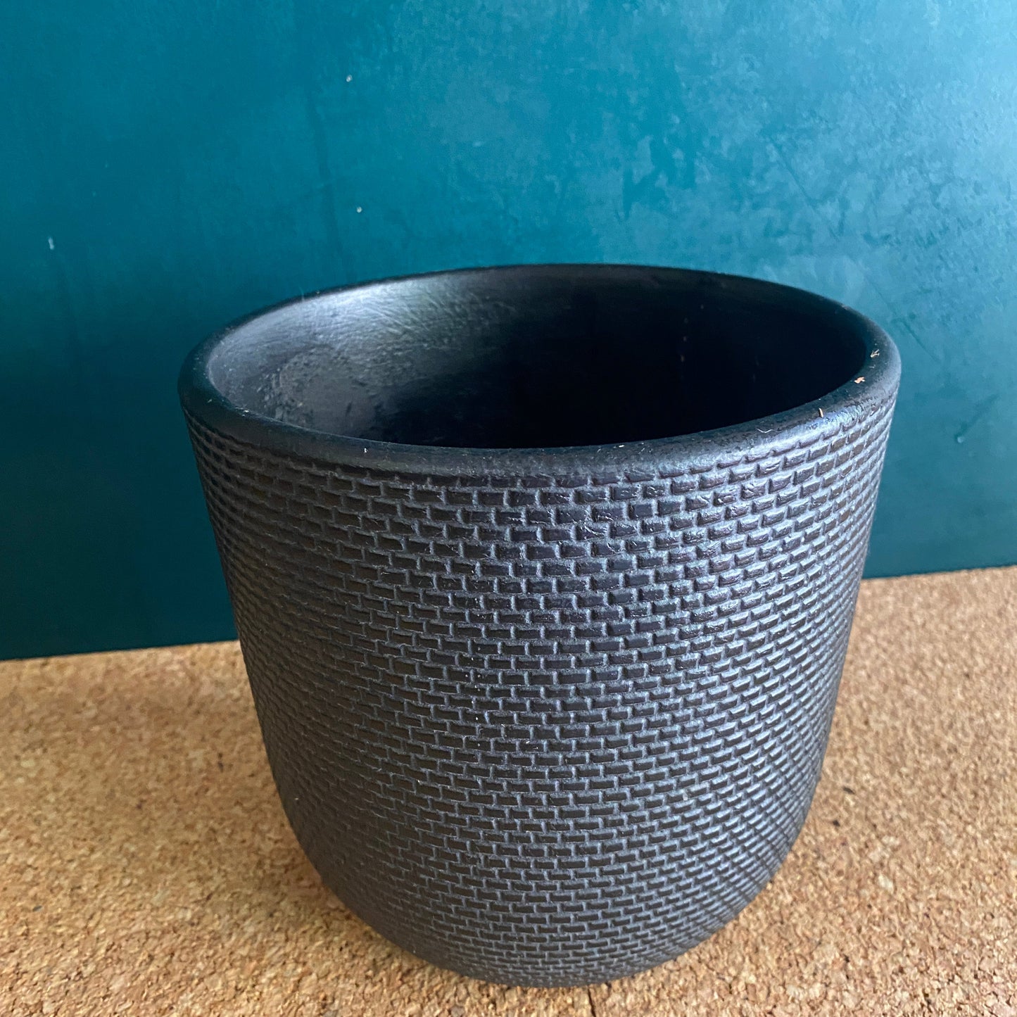 Black patterned round plant pot in matt finish with small chips