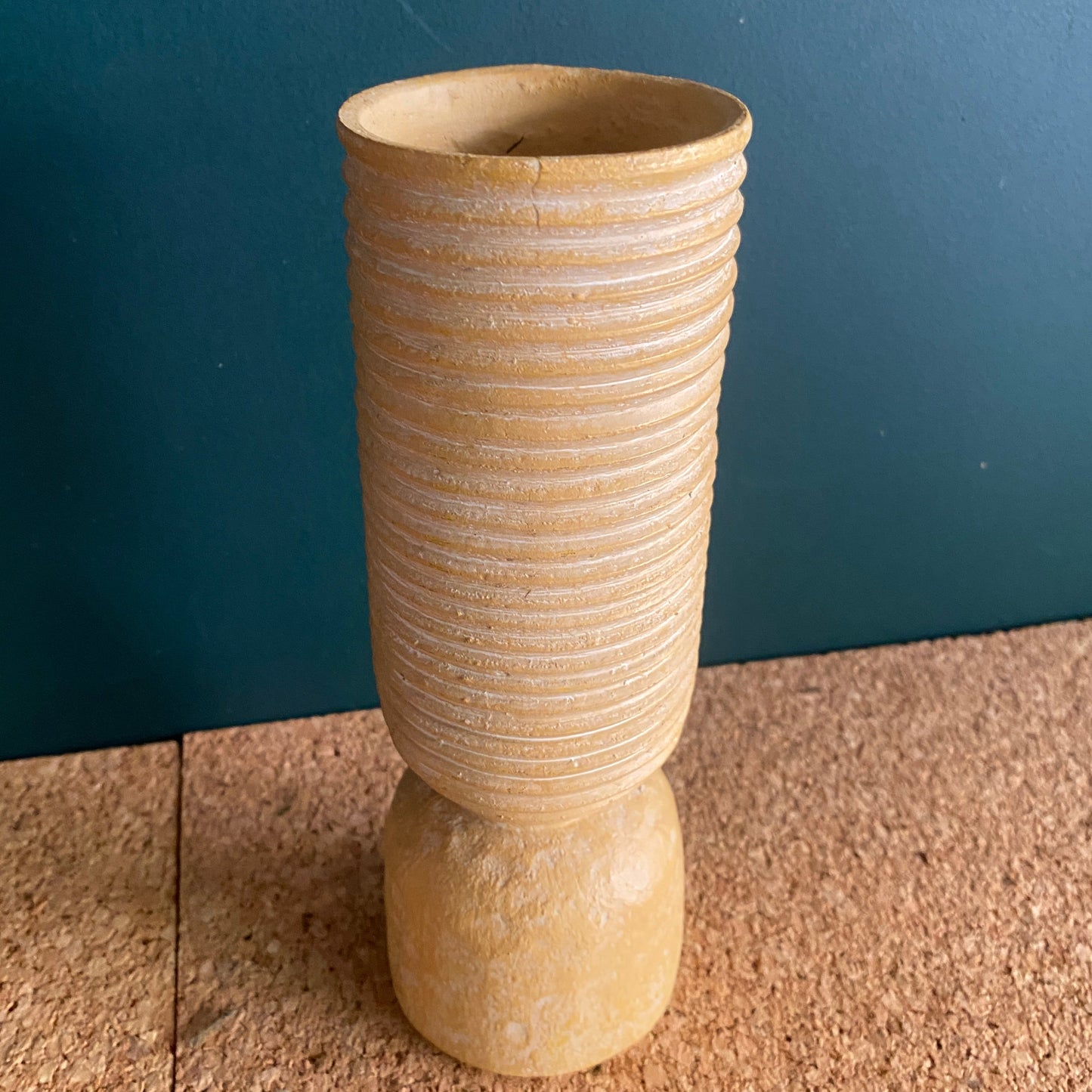 A earthy texture small vase in cylinder shape with ribbed edges