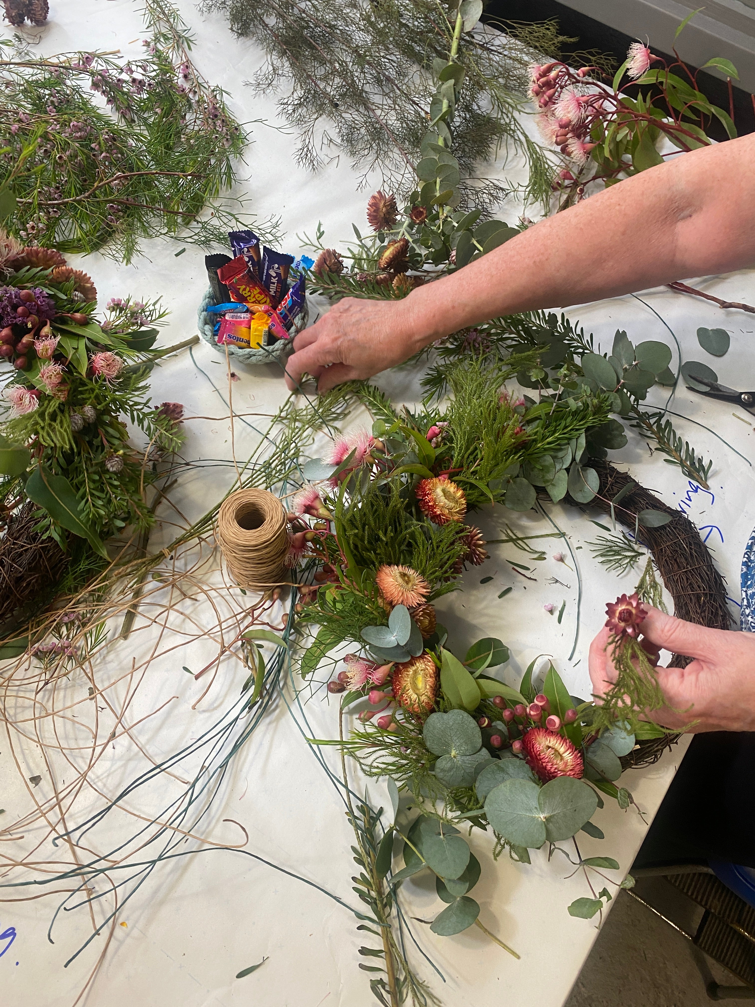 A wreath being made with Australian native flowers on a table in a workshop hosted by Bold Botanicals