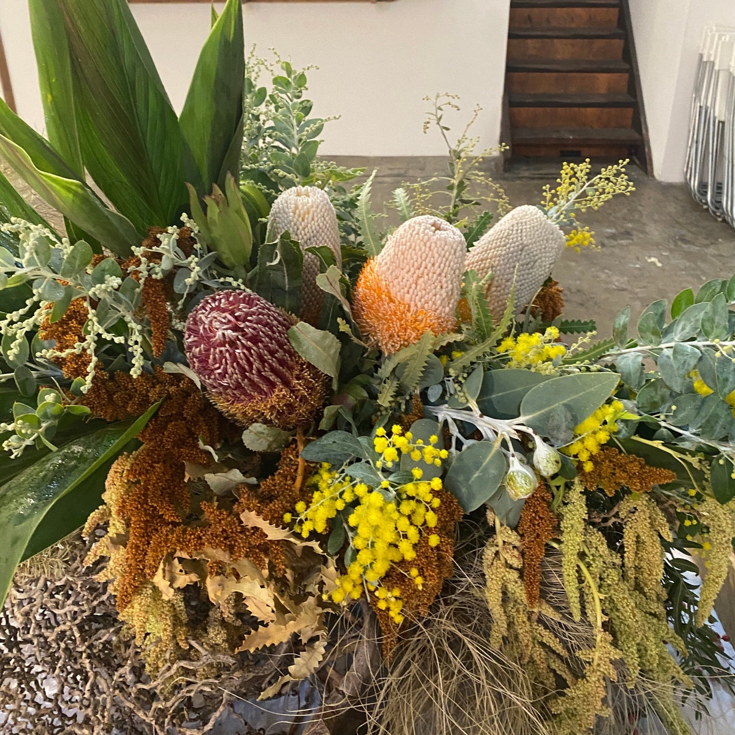 A FULL SIZE warm colour palette Australian native flower arrangement for a funeral casket.