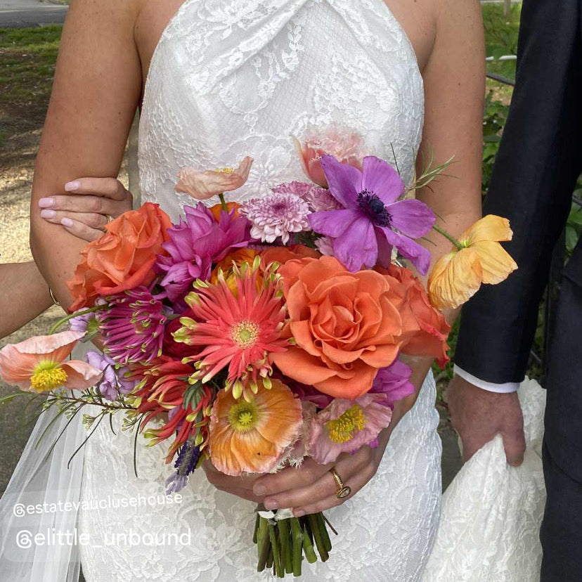 Bride holding a colorful fresh flower bouquet with a park backgound