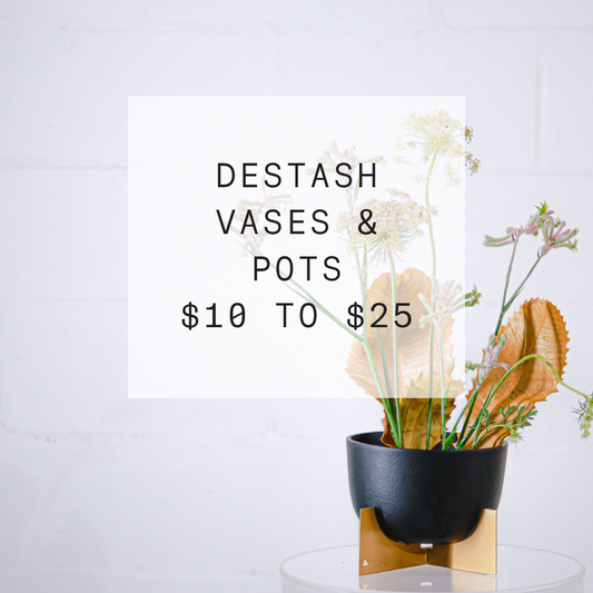Black and gold pots with dried flower arrangement announcing sale on vases