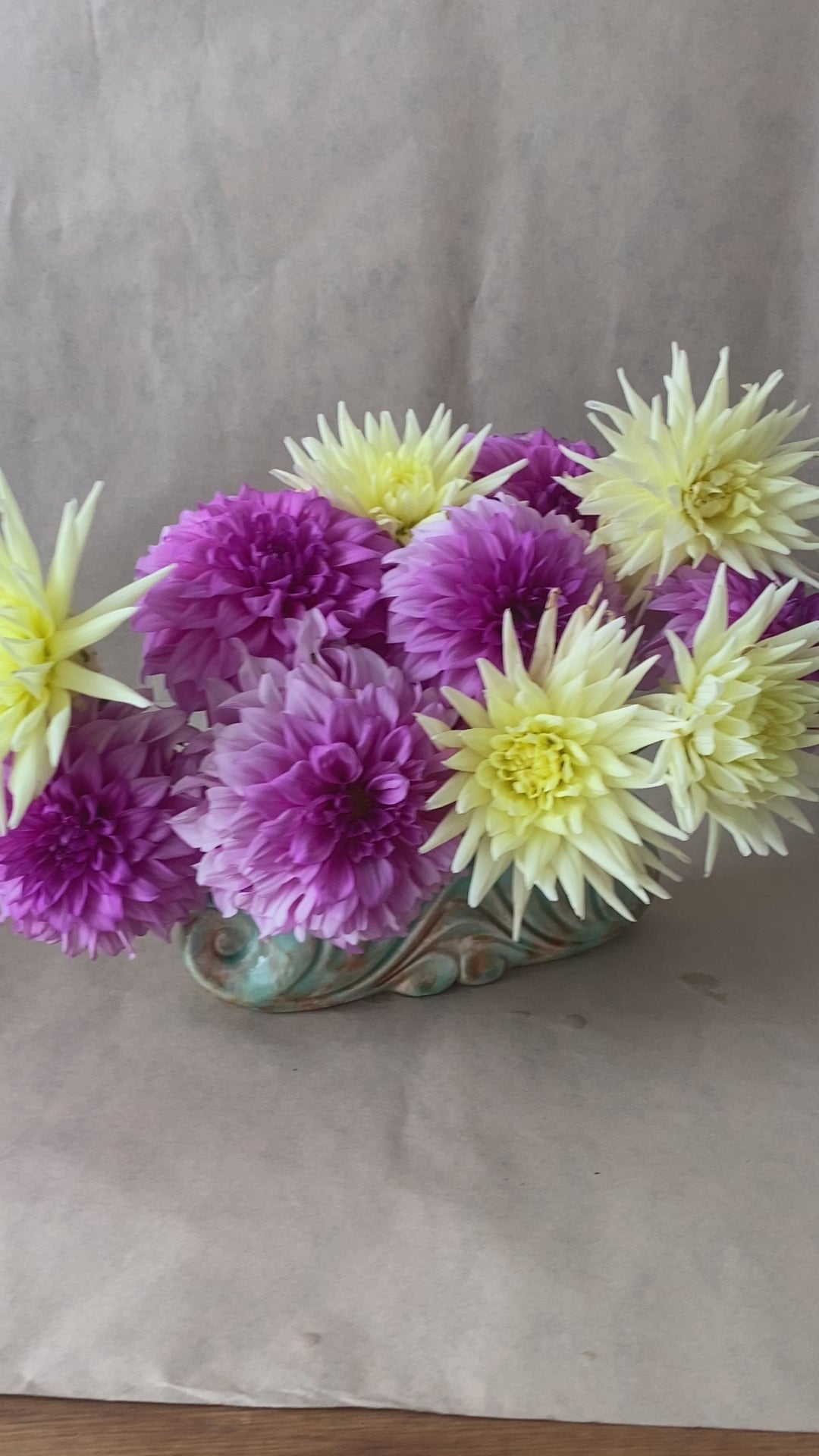 A video showing beautiful pink and yellow home grown Dahlias, arranged with a Bold Botanicals flower pin or Kenzan.